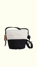 Two-toned black and white bag with a strap on a white background