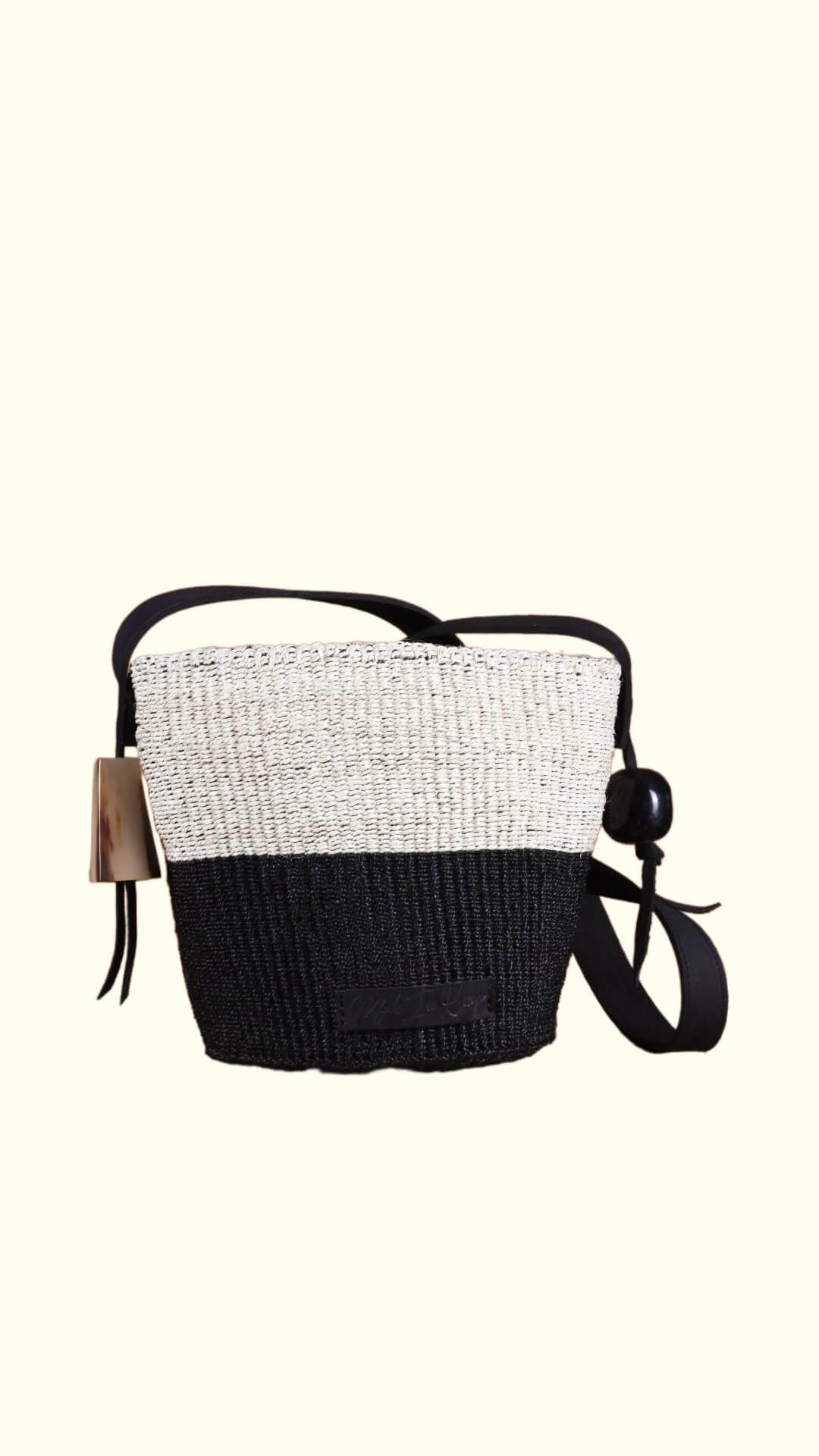 Two-toned black and white bag with a strap on a white background