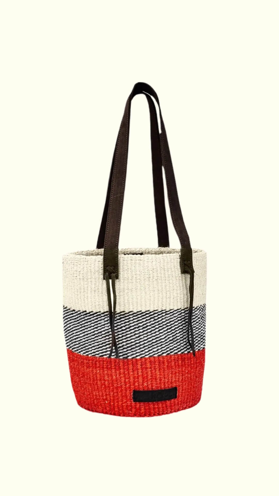 Woven tote bag with red bottom half, black handle, and gray top half on a white background