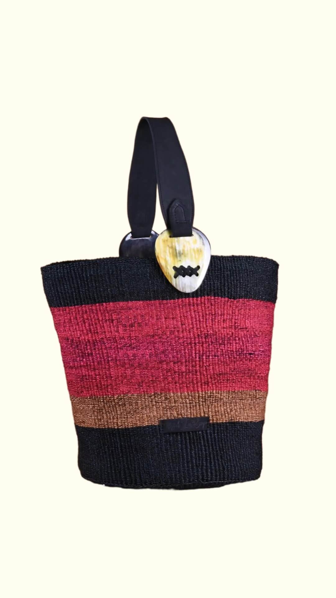 Multicolored striped bag with a heart-shaped tag on a white background