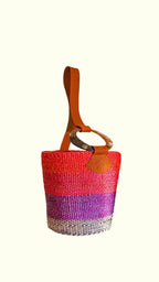 Multicolored woven artisan bag with a brown handle on a white background