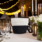 Decorative table setting with a black and white woven basket, candles, and lanterns.